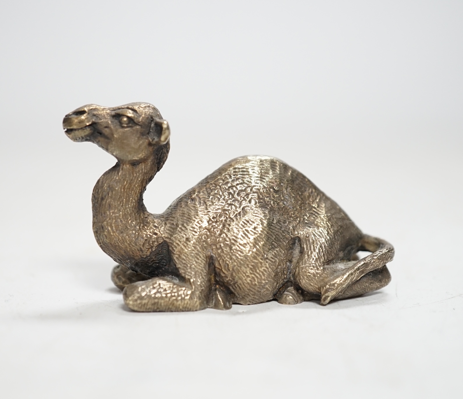 An Elizabeth II miniature silver model of a recumbent camel, by Stuart Devlin, London, 1979, length 58mm.